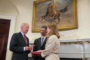 Vice President Joe Biden swears in Sylvia Mathews Burwell, as Secretary of Health and Human Services, with her husband Stephen holding the bible, in the Roosevelt Room of the White House. June 24, 2014. (Official White House Photo by David Lienemann)